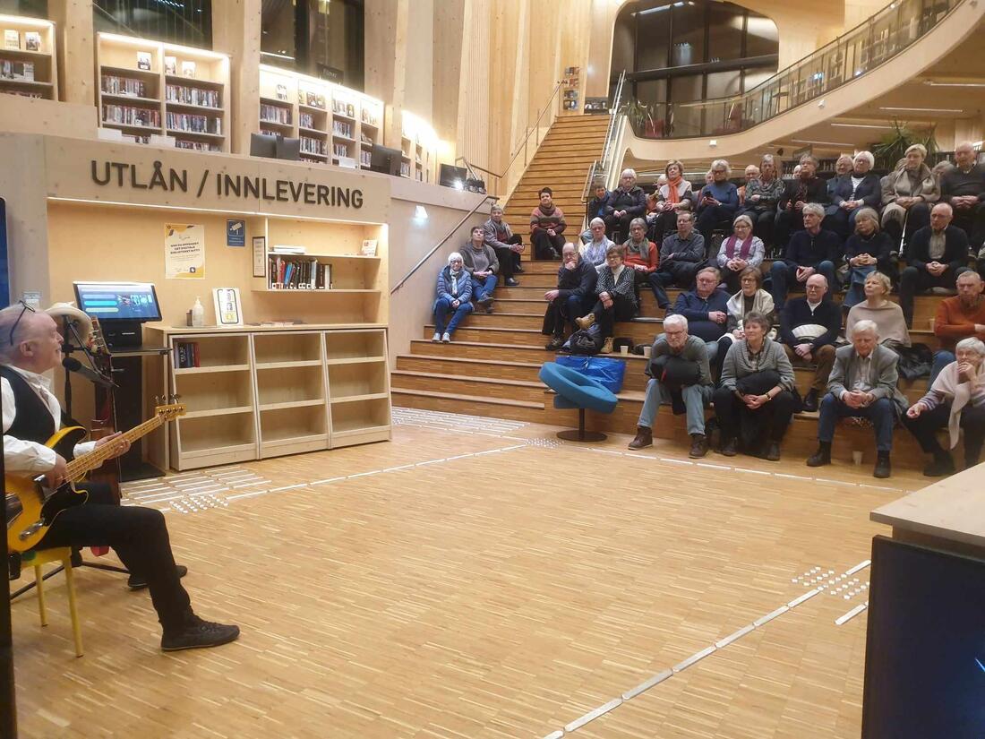 Steve Andersson underholder publikum i et fullsatt Nord-Odal bibliotek